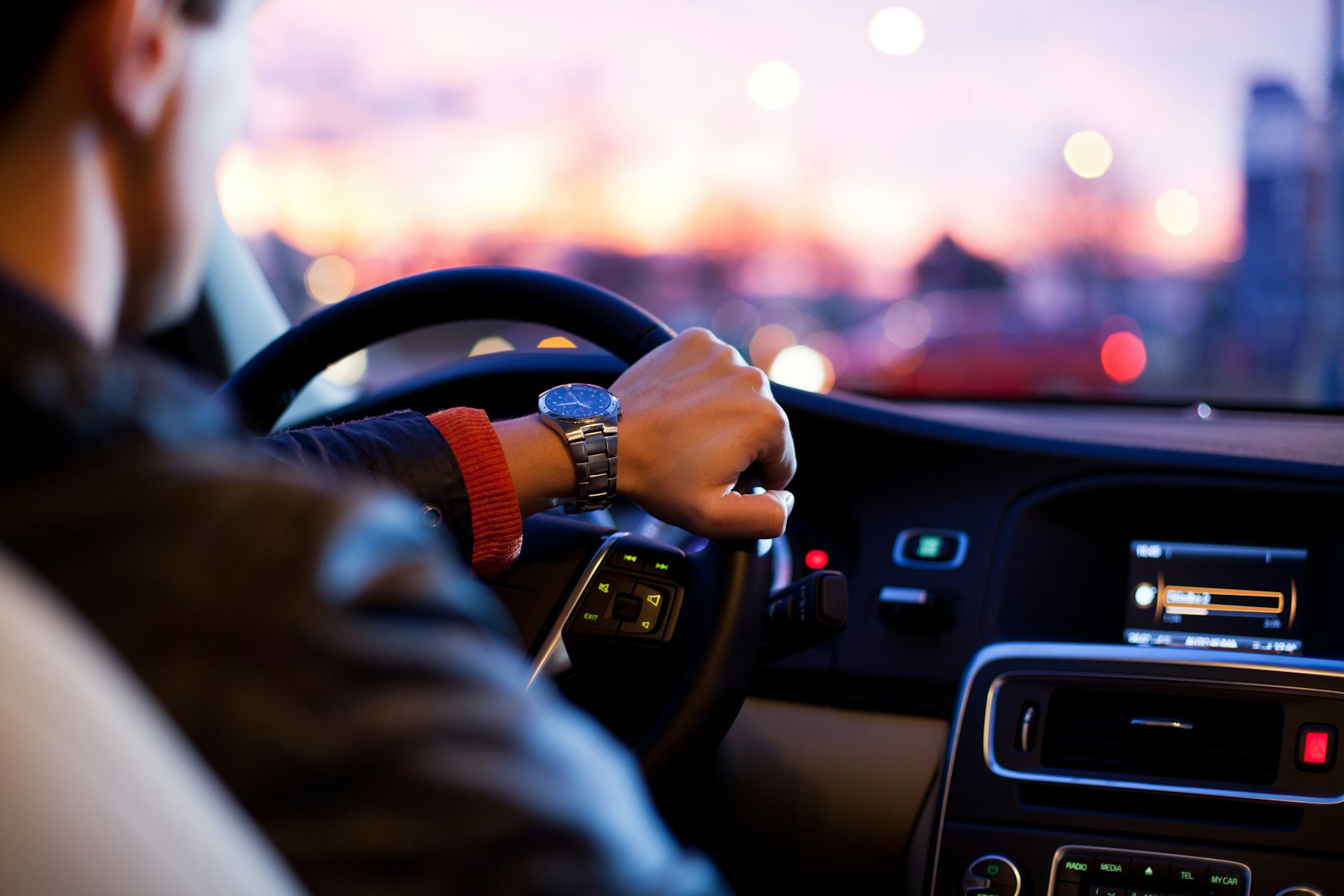 Chauffeur at the wheel of a luxury vehicle at dusk