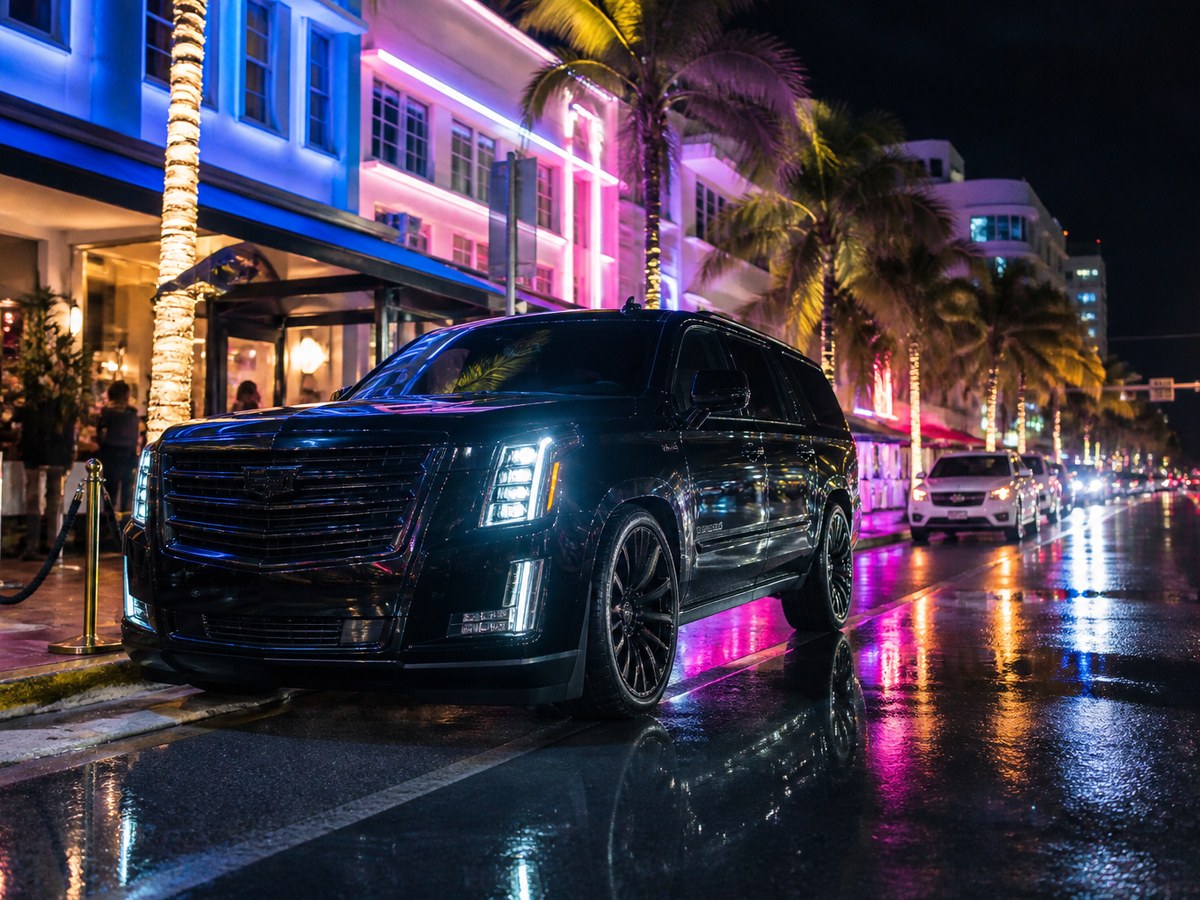 Black SUV parked outside a nightlife venue at night